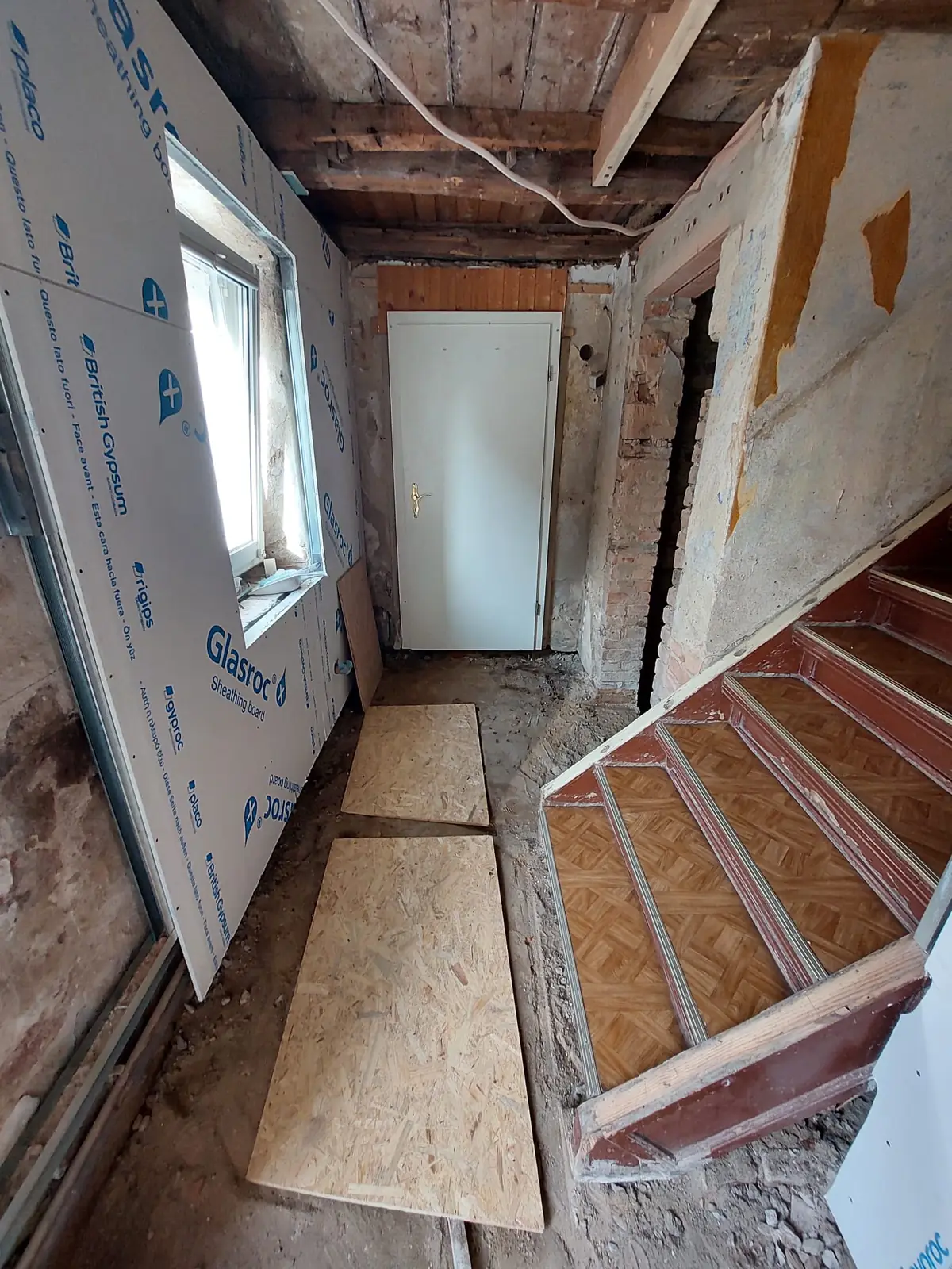 Trockenbauwand neben freigelegter Balkendecke und Ziegelmauerwerk