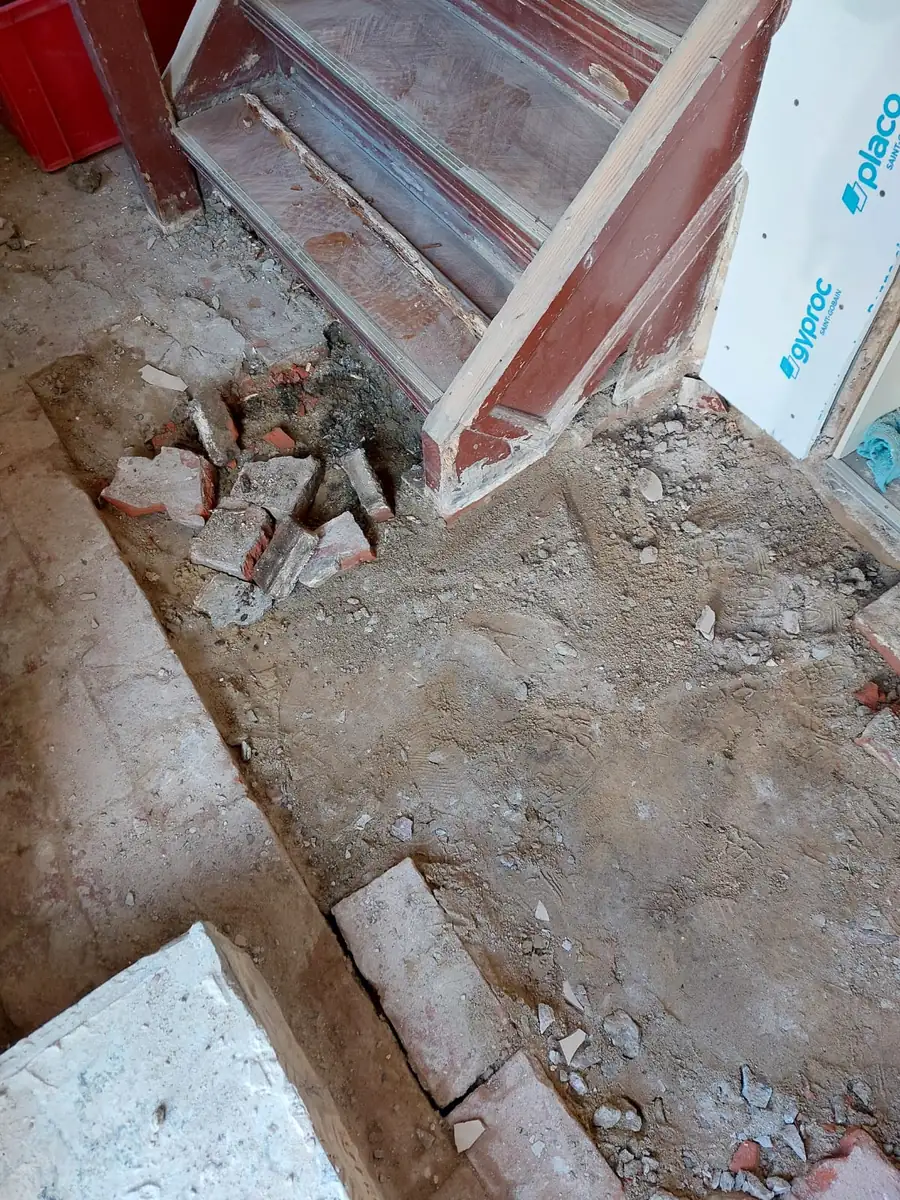Bodenrückbau am Fuß der Treppe mit Bauschutt im Altbau