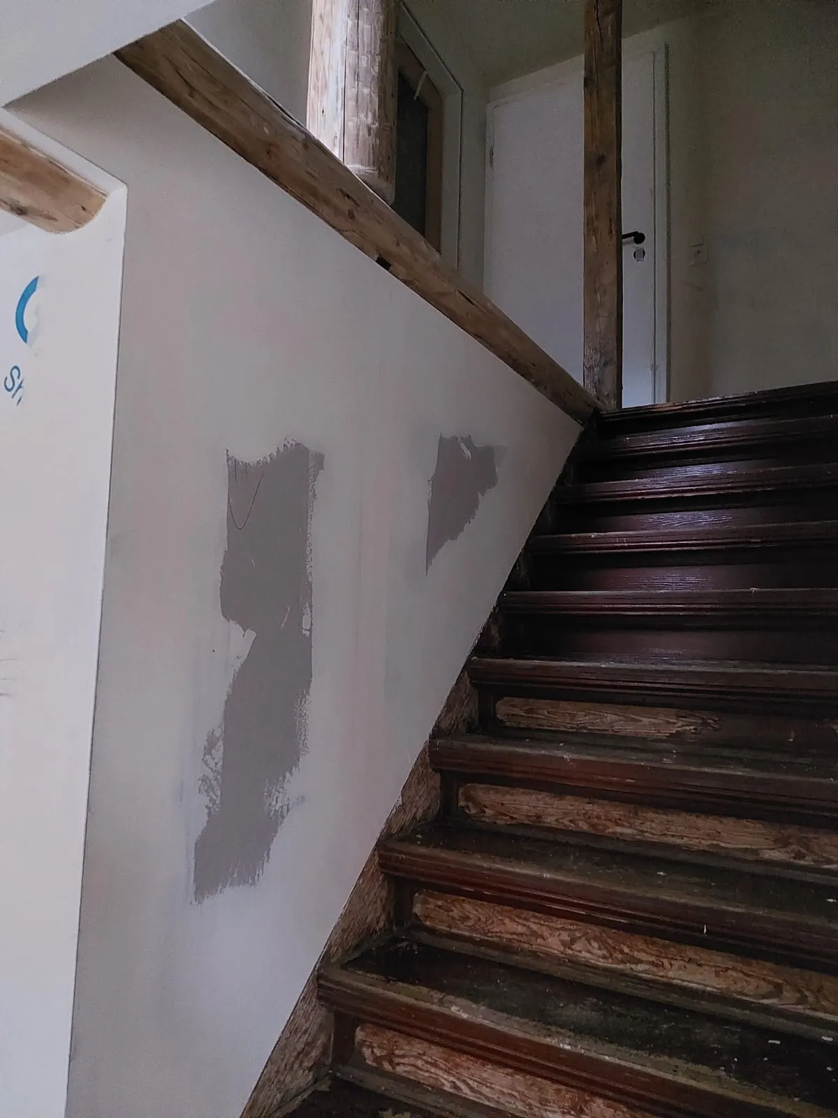 Verspachtelte Trockenbauwand entlang der Treppe mit sichtbaren Holzständern